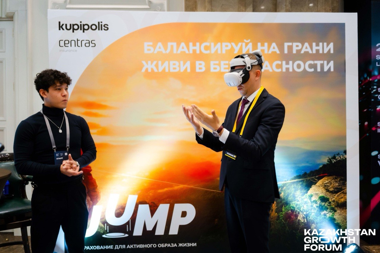 Гость пробует VR на Kazakhstan Growth Forum, рядом инструктор VR Space